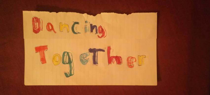Photo of a piece of paper with "Dancing Together" written with different colour pens